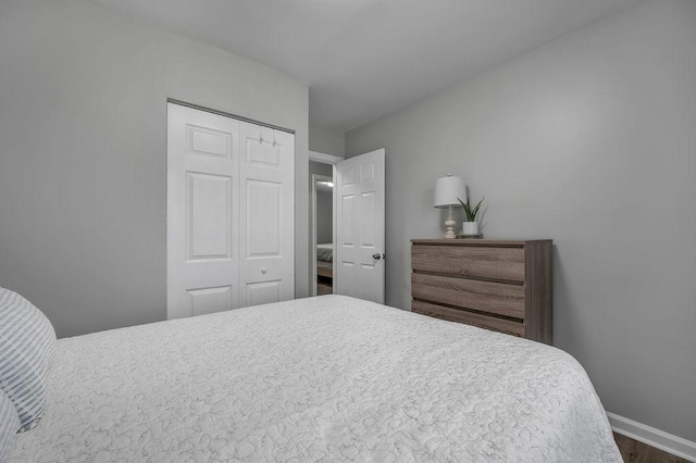 bedroom featuring a closet, baseboards, and wood finished floors