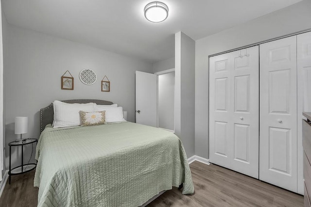 bedroom with a closet, baseboards, and wood finished floors