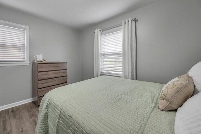 bedroom featuring baseboards and wood finished floors