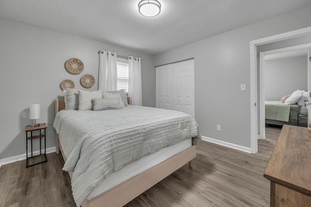 bedroom with baseboards, a closet, and wood finished floors