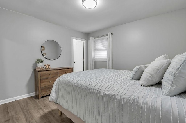 bedroom featuring baseboards and wood finished floors