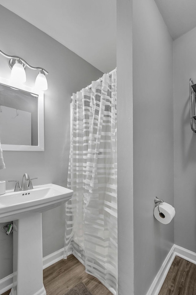 full bath with baseboards, wood finished floors, a sink, and a shower with curtain