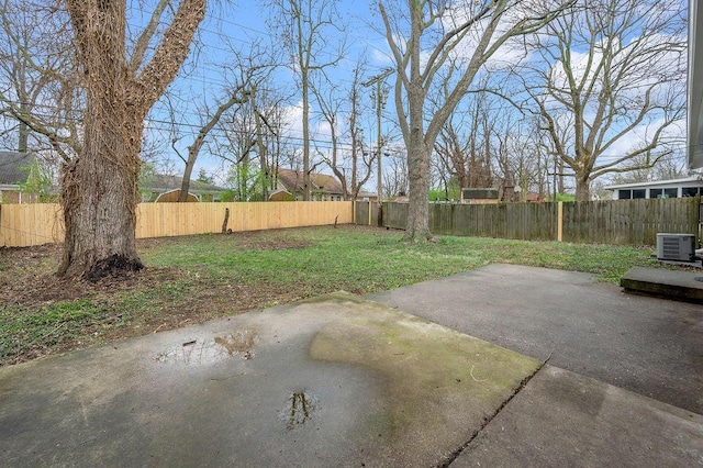 view of yard with a fenced backyard, central AC unit, and a patio