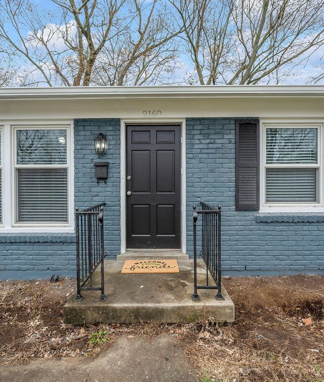 view of exterior entry featuring brick siding