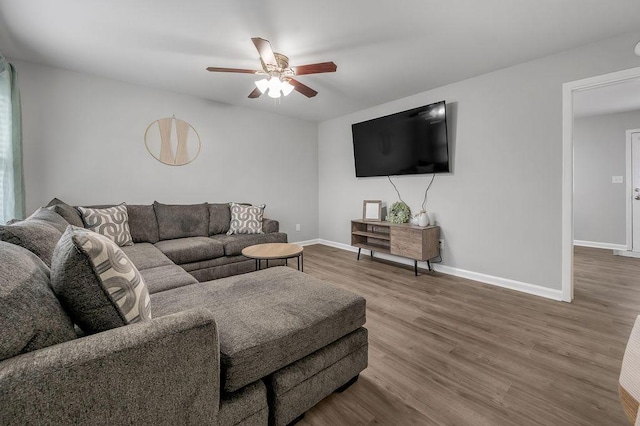 living area featuring baseboards, wood finished floors, and ceiling fan