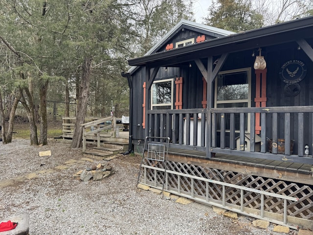 view of side of home featuring covered porch