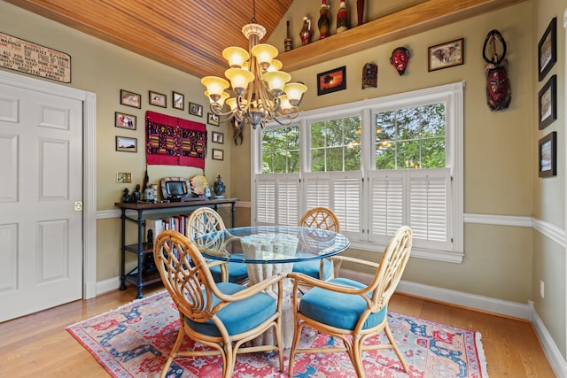 dining room with a chandelier, wood ceiling, vaulted ceiling, wood finished floors, and baseboards