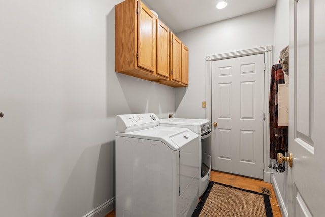 laundry room featuring cabinet space, washing machine and clothes dryer, wood finished floors, recessed lighting, and baseboards