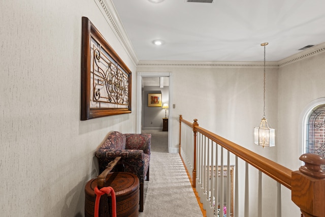 hallway with carpet floors, a chandelier, an upstairs landing, and ornamental molding