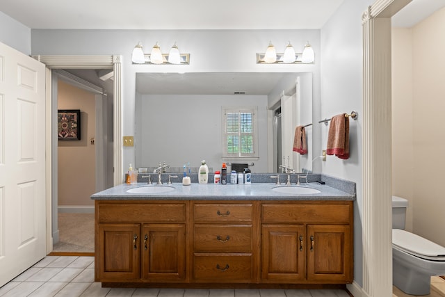 full bath featuring toilet, tile patterned floors, and double vanity
