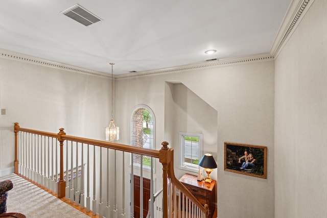 hallway with an upstairs landing, crown molding, wood finished floors, and baseboards