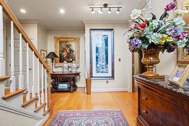 foyer entrance with stairs, light wood-style flooring, and baseboards