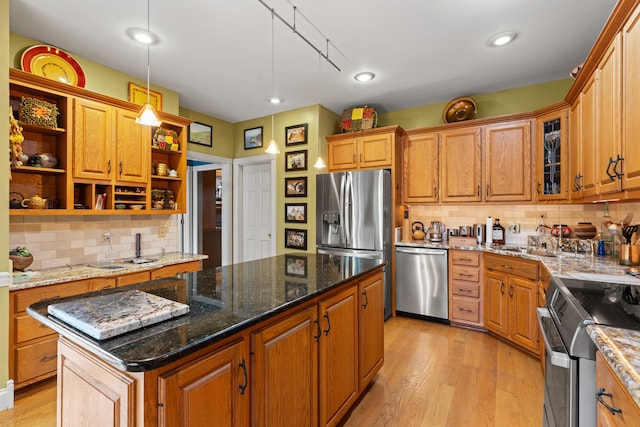 kitchen featuring stainless steel appliances, open shelves, tasteful backsplash, a center island, and light wood-style floors