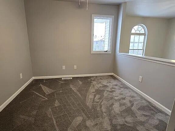 carpeted spare room with baseboards
