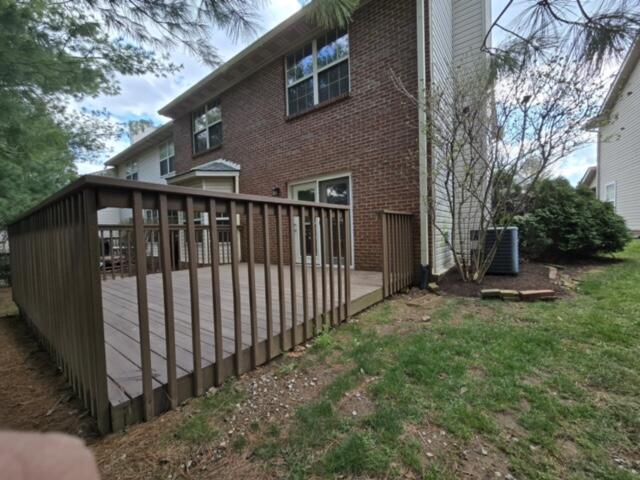 back of house with brick siding, central AC, and a wooden deck