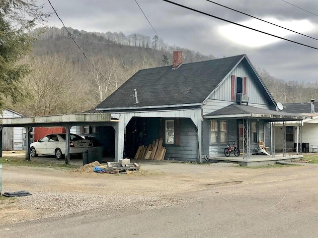 34 Owens Rd S, Clearfield, KY 40313 - view of front facade featuring covered porch, a carport, and a chimney