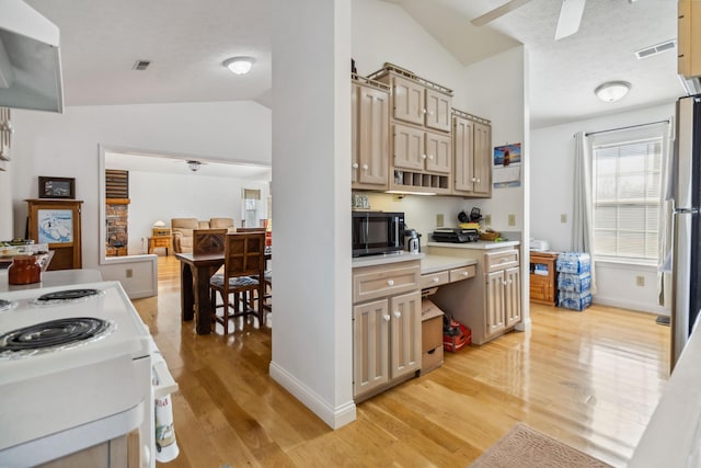 kitchen featuring vaulted ceiling, light countertops, light wood-type flooring, visible vents, and ceiling fan