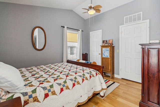 bedroom featuring visible vents, baseboards, a ceiling fan, lofted ceiling, and light wood-type flooring