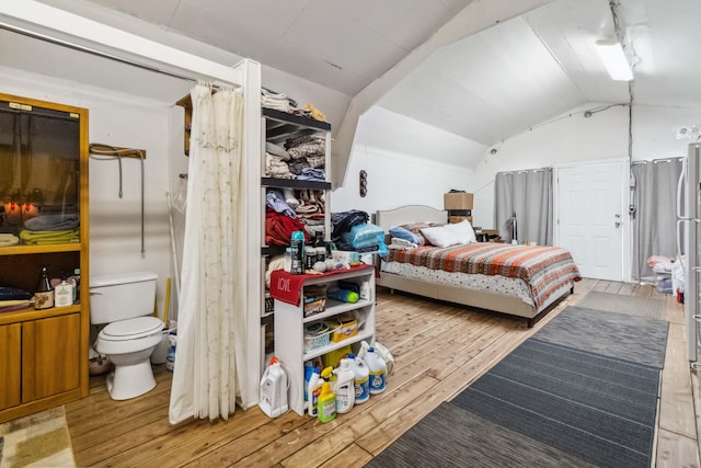 bedroom with hardwood / wood-style flooring and lofted ceiling