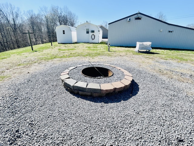 view of yard with an outdoor fire pit, a pole building, and an outbuilding