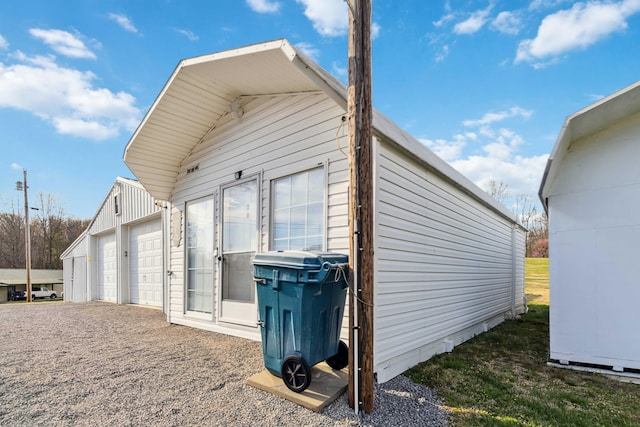 view of side of home featuring an outbuilding and a garage