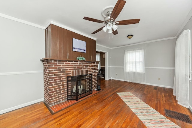 unfurnished living room with a ceiling fan, visible vents, a fireplace, ornamental molding, and hardwood / wood-style floors