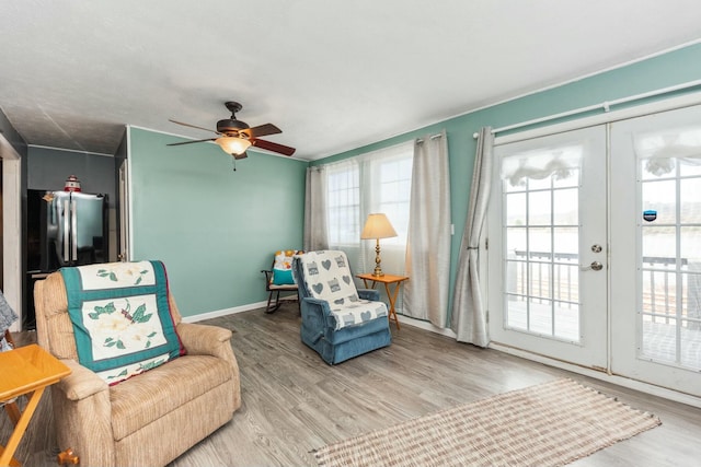sitting room featuring baseboards, ceiling fan, and wood finished floors