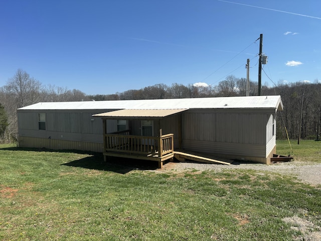 back of property featuring a wooden deck and a yard