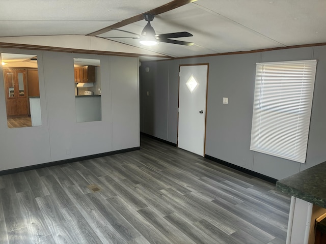 unfurnished living room featuring vaulted ceiling with beams, wood finished floors, and a ceiling fan