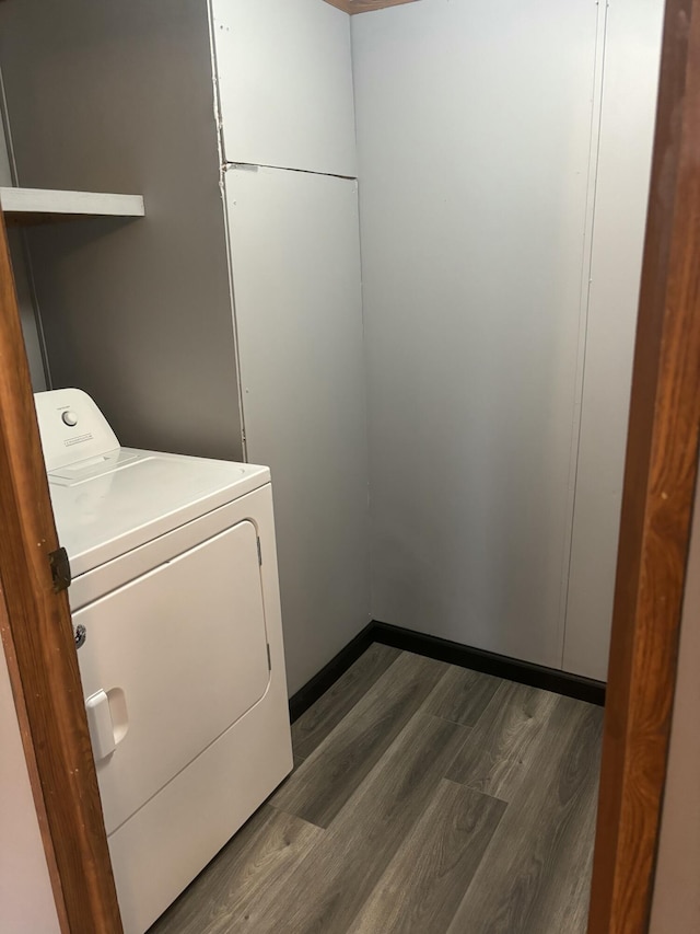 clothes washing area featuring dark wood-type flooring, washer / clothes dryer, and laundry area