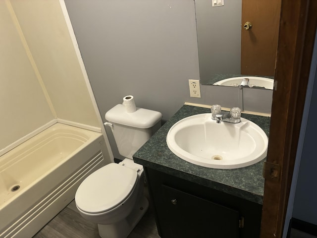 bathroom featuring a bathing tub, toilet, and vanity