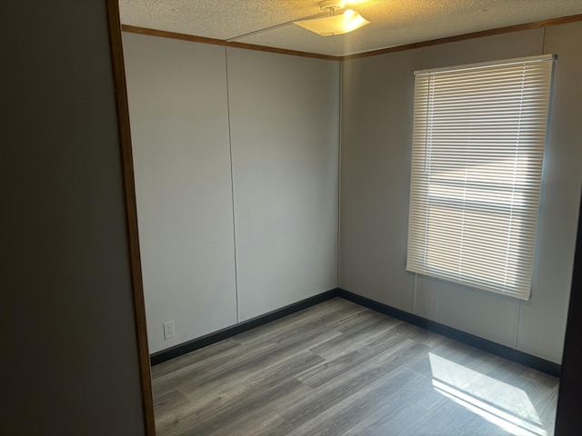 empty room featuring a ceiling fan, light wood-style floors, and a textured ceiling