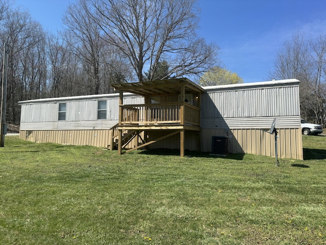 rear view of property featuring central AC unit, a yard, and a wooden deck