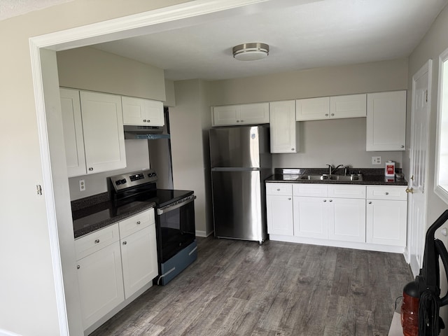 kitchen featuring dark wood-style flooring, under cabinet range hood, a sink, dark countertops, and appliances with stainless steel finishes