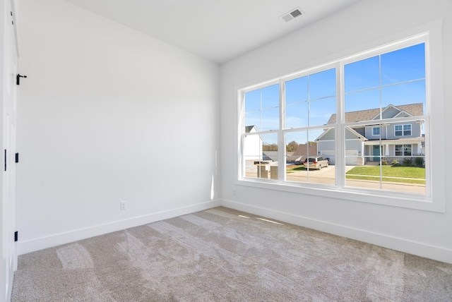 carpeted empty room with baseboards and visible vents