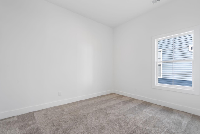 spare room featuring baseboards and carpet floors