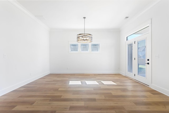 unfurnished dining area with light wood finished floors, a notable chandelier, baseboards, and crown molding