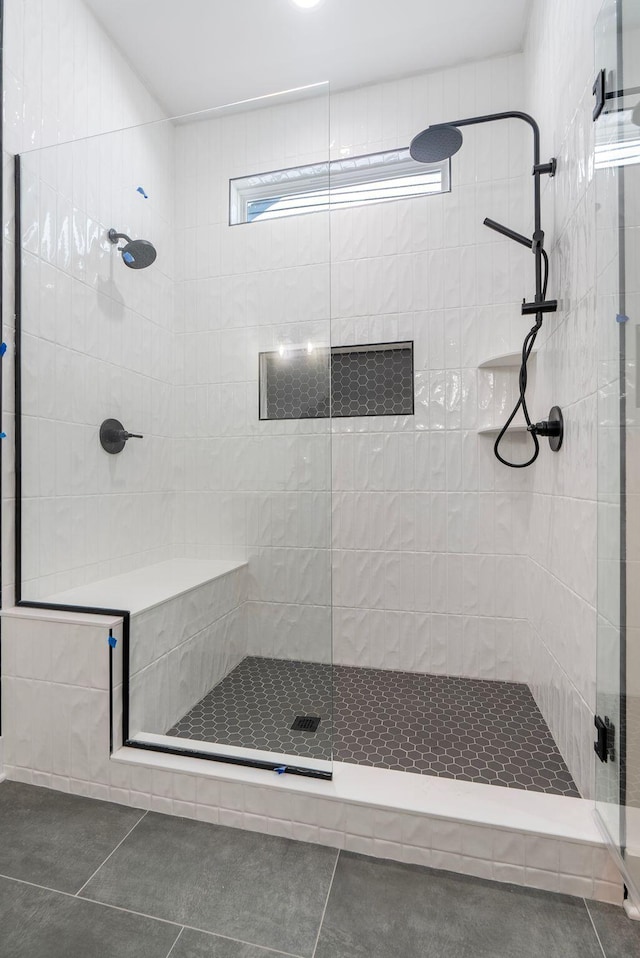 bathroom with a shower stall and tile patterned floors