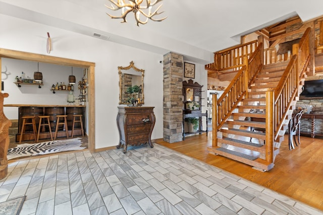 1295 Burger Knob Rd, Junction City, KY 40440 - stairs featuring a bar, wood finished floors, a chandelier, and visible vents