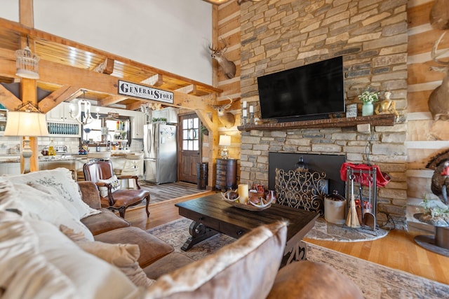1295 Burger Knob Rd, Junction City, KY 40440 - living room featuring a high ceiling, a chandelier, light wood-style floors, and a stone fireplace