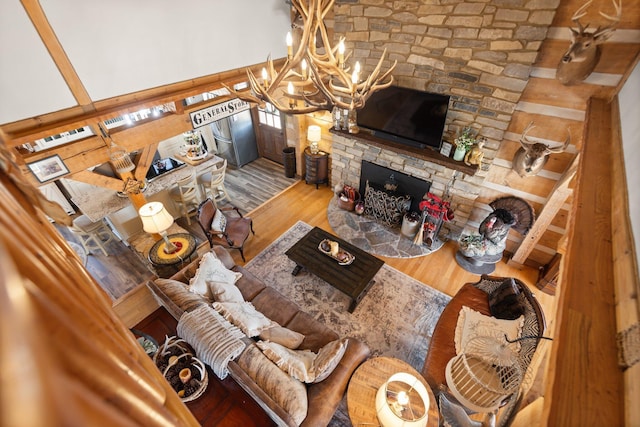 1295 Burger Knob Rd, Junction City, KY 40440 - living room with wood finished floors, a chandelier, and a stone fireplace