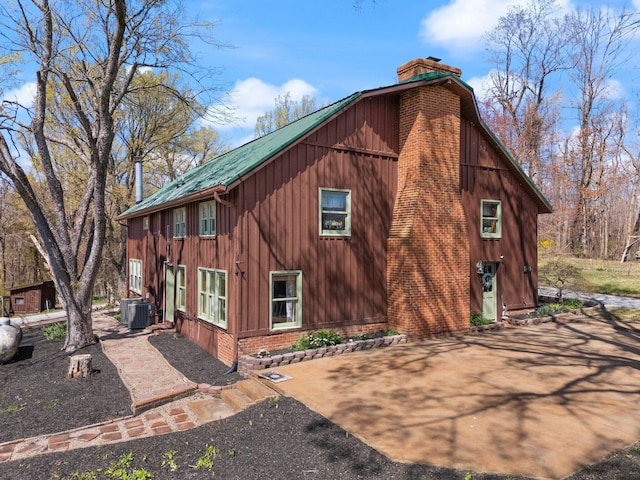 1295 Burger Knob Rd, Junction City, KY 40440 - view of home's exterior featuring central air condition unit, a chimney, board and batten siding, brick siding, and metal roof