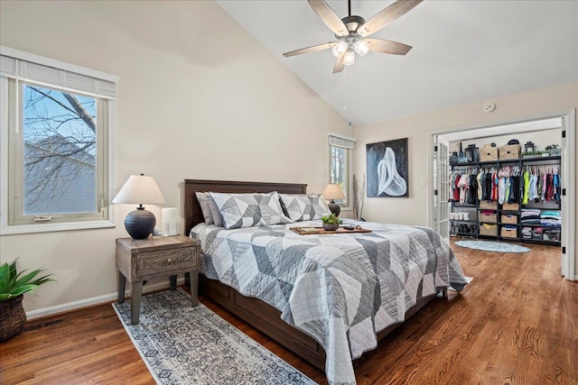 bedroom with baseboards, a closet, ceiling fan, high vaulted ceiling, and wood finished floors