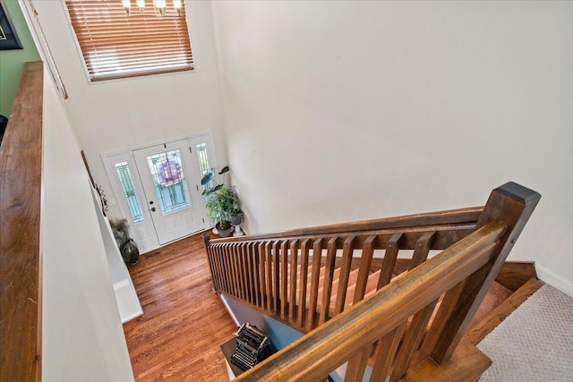 foyer featuring stairs, a towering ceiling, and wood finished floors