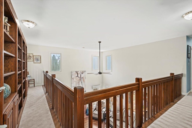 hall with baseboards and an upstairs landing