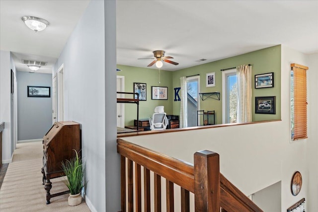 hall with carpet, visible vents, and baseboards