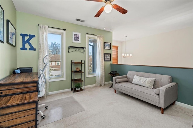 office area with carpet floors, baseboards, visible vents, and ceiling fan with notable chandelier