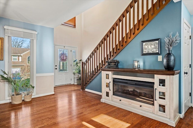 foyer entrance with baseboards, stairway, and wood finished floors