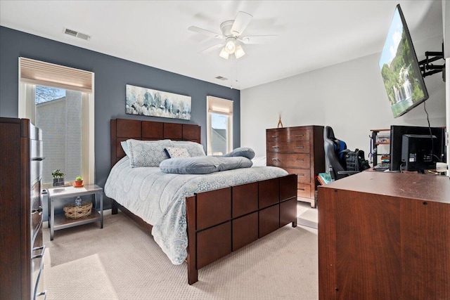 bedroom featuring light carpet, visible vents, and ceiling fan