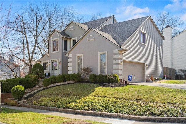traditional home featuring a garage, stucco siding, a front lawn, driveway, and roof with shingles